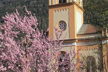 ein Uhrturm vor einem Backsteingebäude